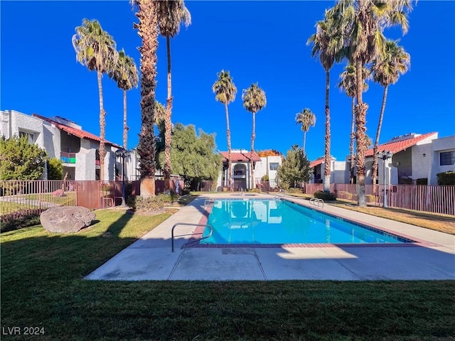 view of pool with a patio area and a lawn