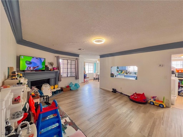 rec room with hardwood / wood-style floors, a textured ceiling, and ornamental molding