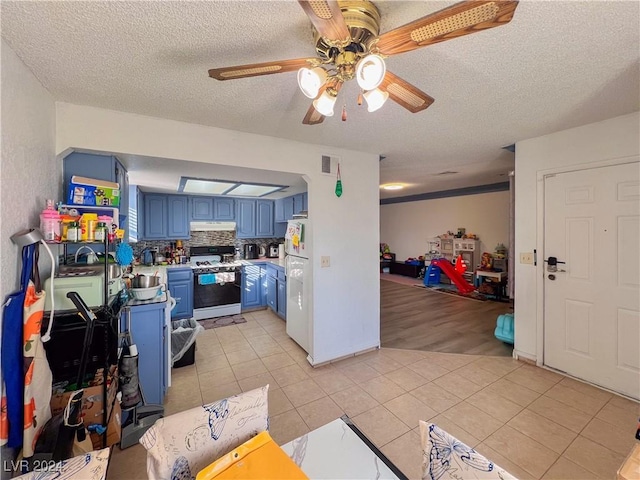 kitchen with blue cabinetry, a textured ceiling, white appliances, and light wood-type flooring