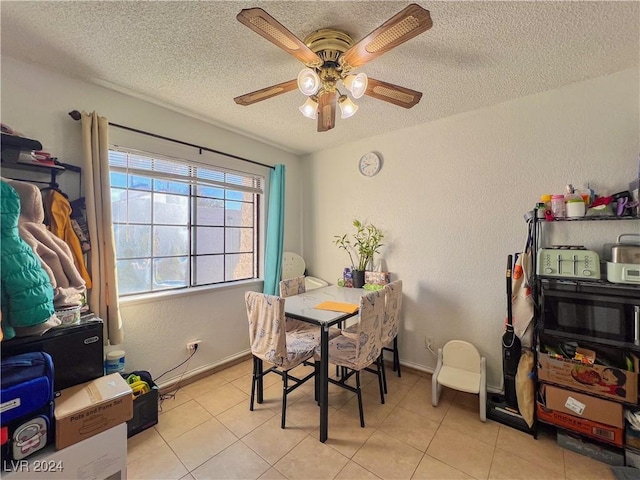 dining space with ceiling fan, light tile patterned floors, and a textured ceiling