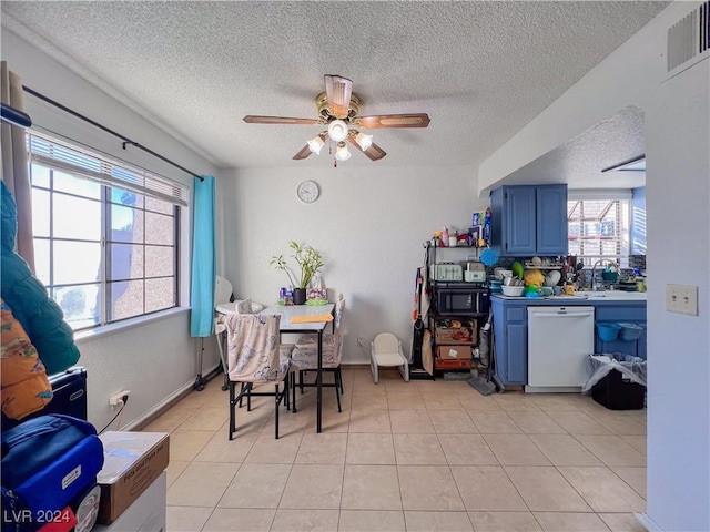 tiled dining room featuring a textured ceiling, ceiling fan, and sink