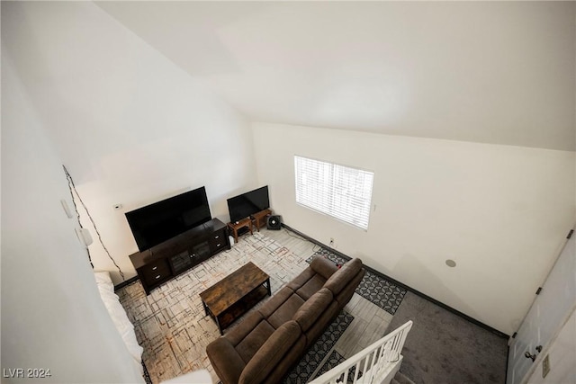 unfurnished living room featuring carpet and vaulted ceiling