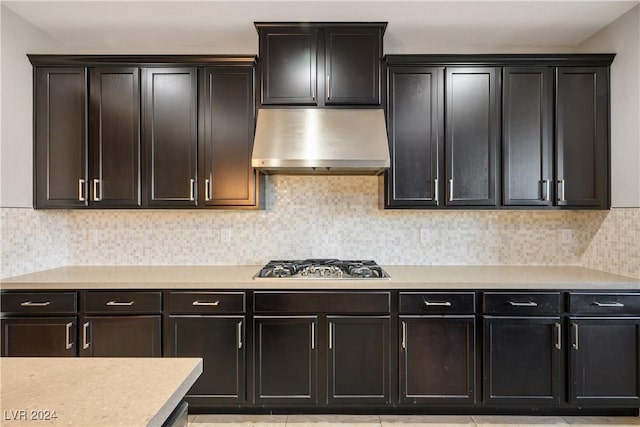 kitchen with decorative backsplash, extractor fan, stainless steel gas cooktop, and light tile patterned flooring