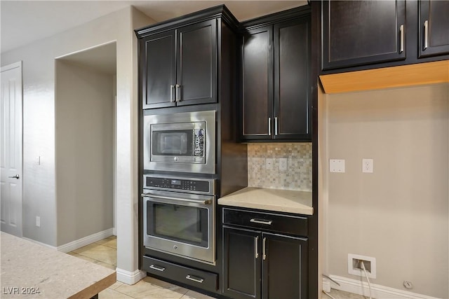 kitchen with decorative backsplash, light tile patterned floors, and stainless steel appliances