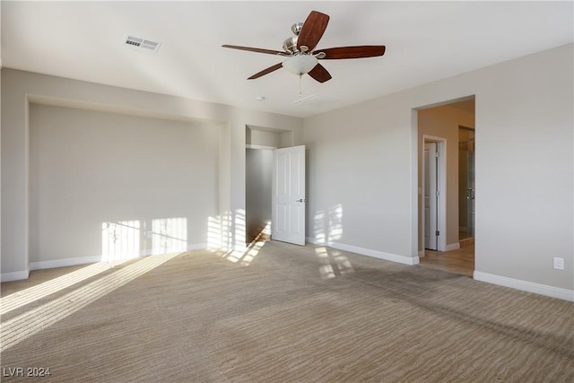 interior space featuring ceiling fan, light colored carpet, and a closet