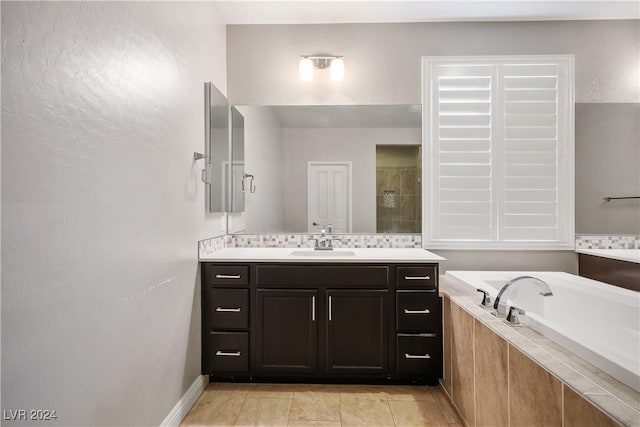 bathroom featuring tile patterned floors, vanity, and tiled tub