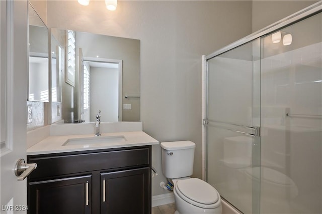 bathroom featuring vanity, toilet, and an enclosed shower