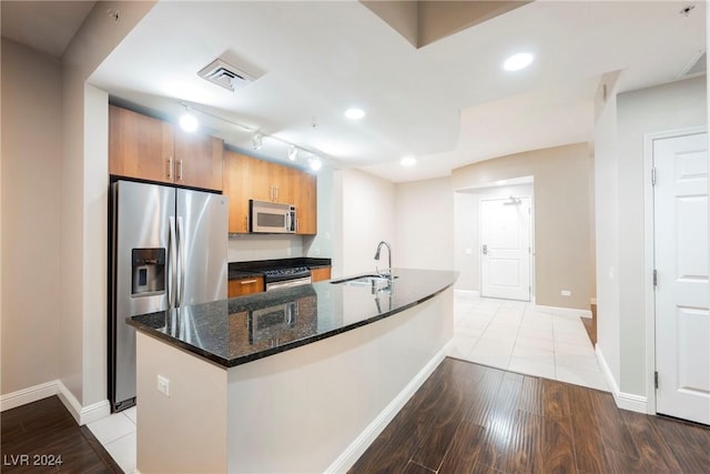 200 W Sahara Ave Unit 1510, Las Vegas, NV 89102 - kitchen featuring appliances with stainless steel finishes, light wood-style flooring, recessed lighting, a center island with sink, and dark stone countertops