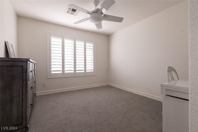 spare room with dark colored carpet and ceiling fan