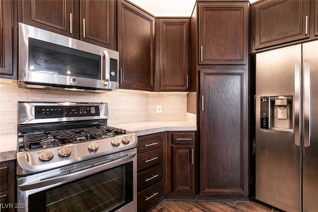 kitchen featuring backsplash, dark hardwood / wood-style floors, dark brown cabinets, and stainless steel appliances