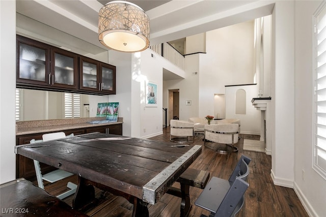 dining space with dark hardwood / wood-style floors and a high ceiling