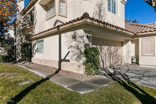 view of side of home with a garage and a yard