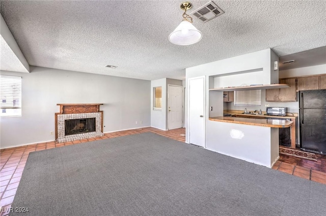 unfurnished living room with dark tile patterned flooring, a fireplace, and a textured ceiling