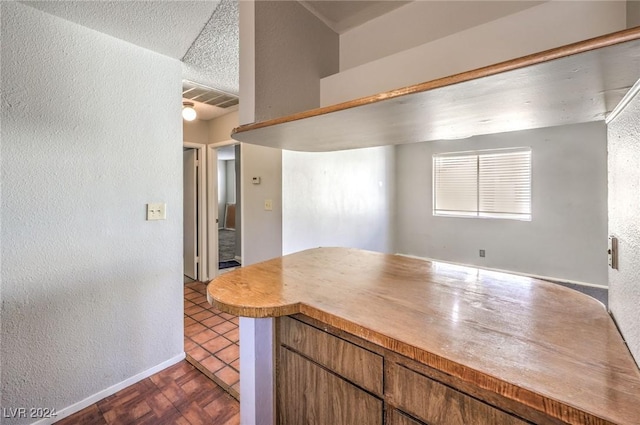 kitchen featuring dark tile patterned flooring and a textured ceiling