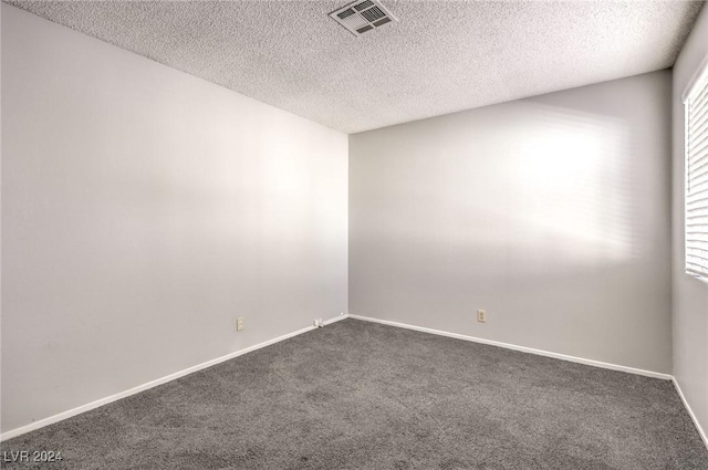 carpeted spare room with a textured ceiling