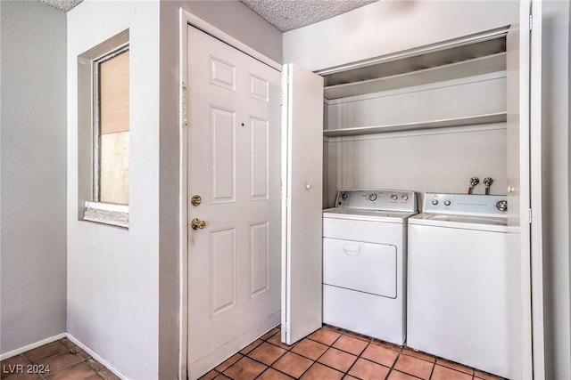 clothes washing area with separate washer and dryer, a textured ceiling, and light tile patterned floors