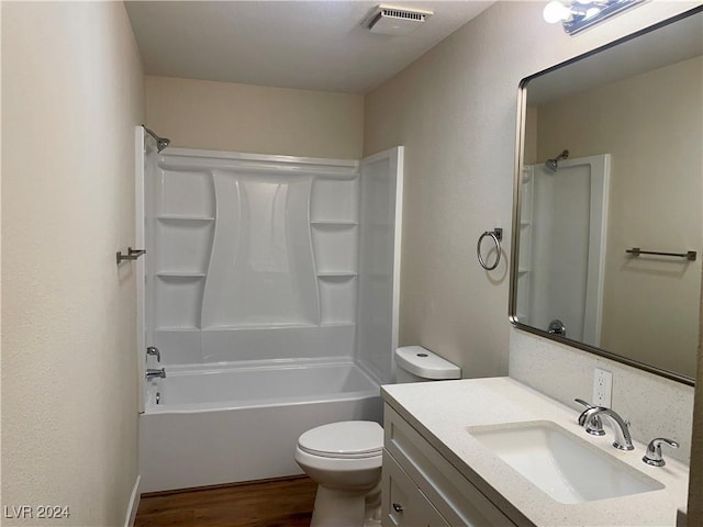 full bathroom featuring hardwood / wood-style floors, vanity,  shower combination, and toilet