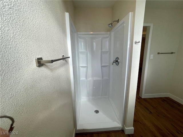 bathroom featuring a shower and wood-type flooring