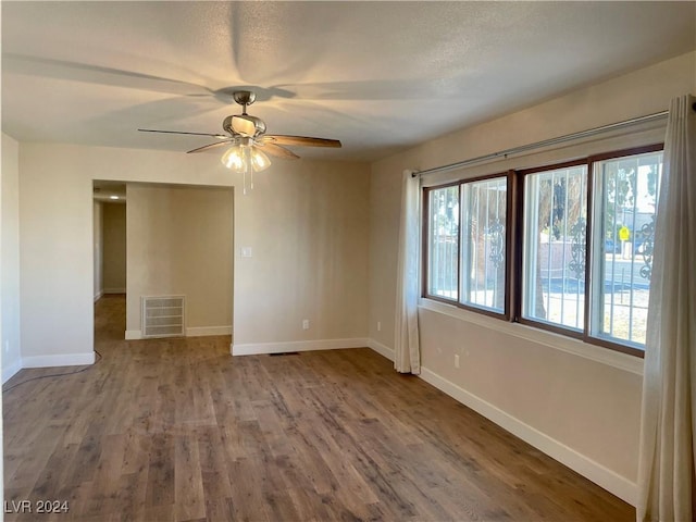 unfurnished room with hardwood / wood-style flooring, ceiling fan, and a wealth of natural light