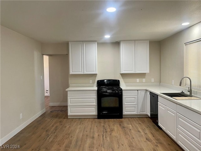 kitchen featuring sink, white cabinets, black appliances, and light hardwood / wood-style floors