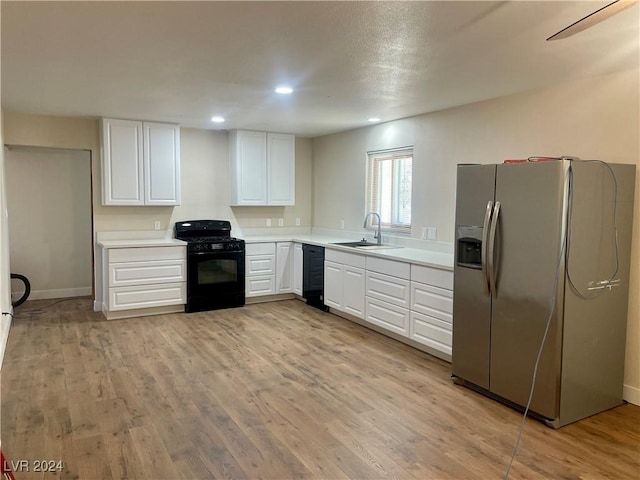 kitchen with sink, white cabinets, black appliances, and light wood-type flooring