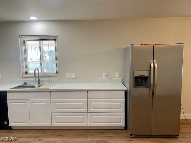 kitchen featuring sink, white cabinetry, stainless steel refrigerator with ice dispenser, and light hardwood / wood-style flooring