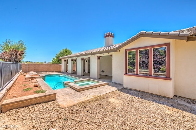 rear view of house featuring a swimming pool with hot tub