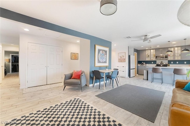 living room featuring ceiling fan and light wood-type flooring