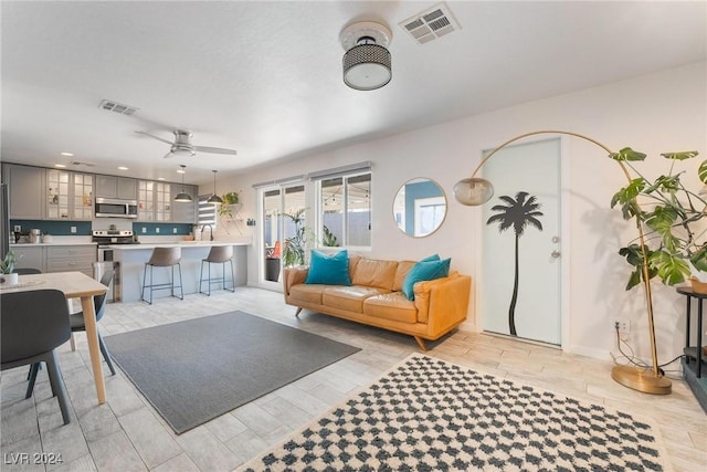 living room featuring ceiling fan and light wood-type flooring