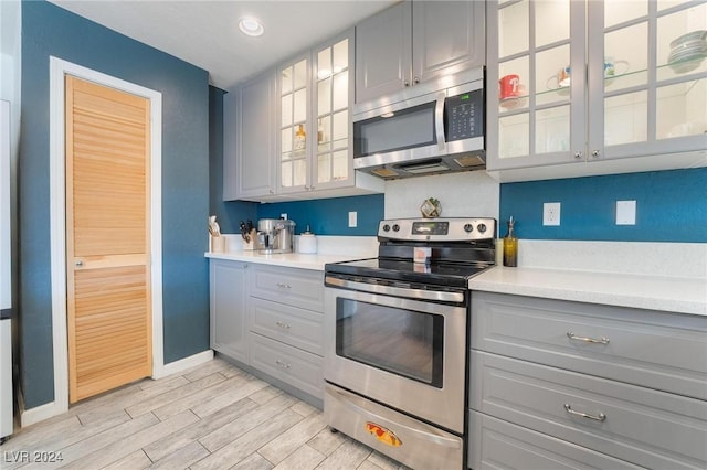 kitchen featuring gray cabinetry, light hardwood / wood-style floors, and stainless steel appliances