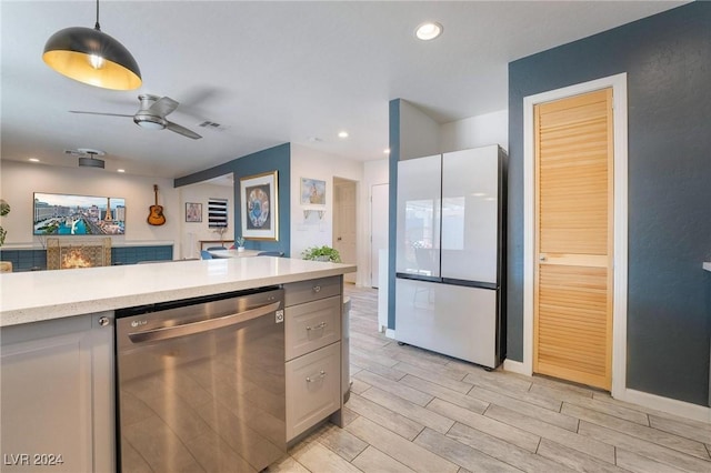 kitchen featuring dishwasher, white refrigerator, ceiling fan, decorative light fixtures, and light hardwood / wood-style floors