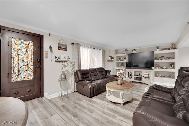 living room with ornamental molding and light hardwood / wood-style flooring