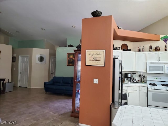 kitchen featuring tile counters, white cabinets, and white appliances