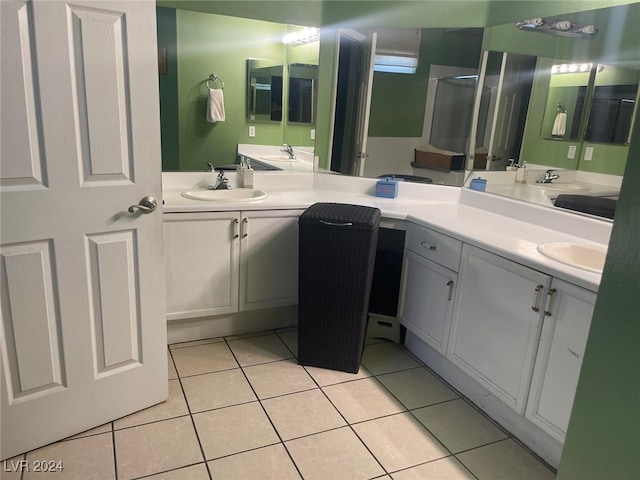 bathroom with tile patterned floors, a shower with door, and vanity