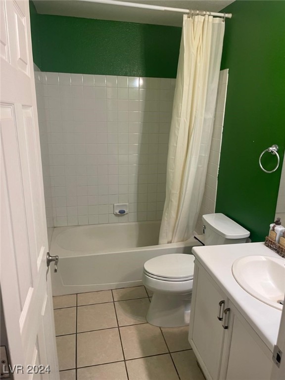 full bathroom featuring tile patterned floors, shower / bath combo with shower curtain, vanity, and toilet