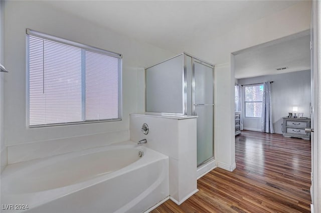 bathroom with independent shower and bath and hardwood / wood-style flooring