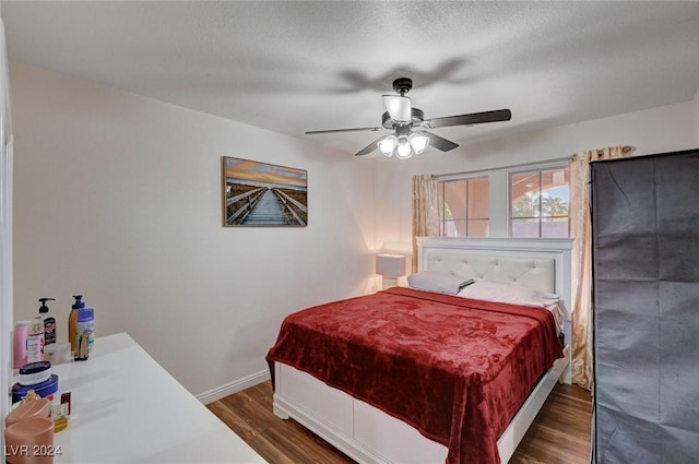 bedroom featuring a textured ceiling, ceiling fan, and dark hardwood / wood-style floors