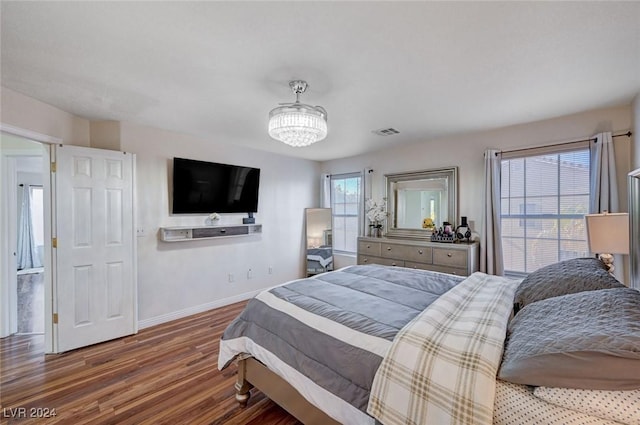 bedroom with a notable chandelier and hardwood / wood-style flooring