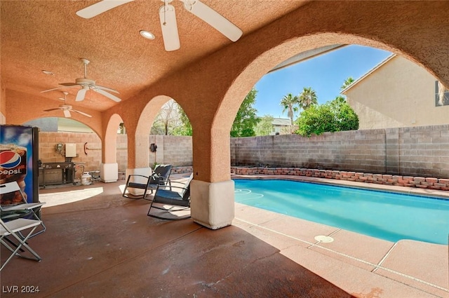 view of swimming pool with ceiling fan and a patio