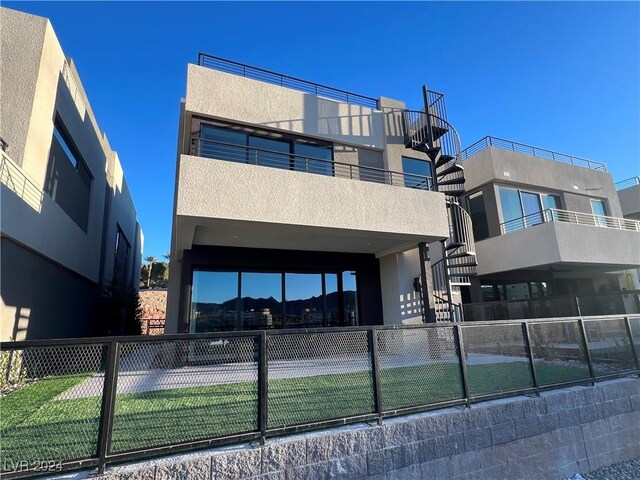 view of building exterior featuring fence and stairway