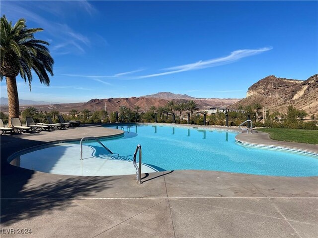 community pool with a patio area and a mountain view