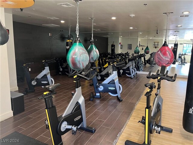 exercise room with wood finish floors, visible vents, and recessed lighting