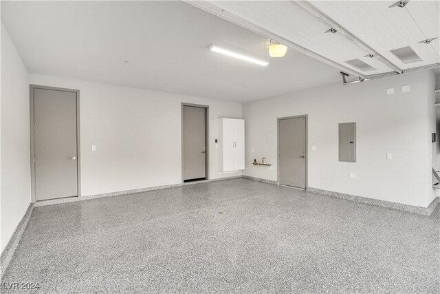 garage featuring electric panel and baseboards