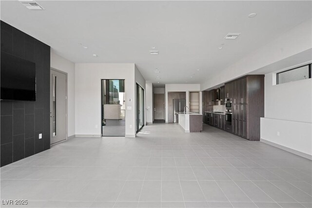 unfurnished living room featuring visible vents and baseboards