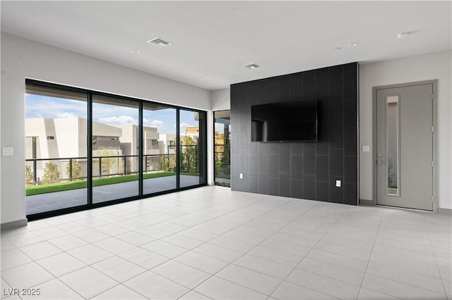 unfurnished living room with light tile patterned flooring and visible vents