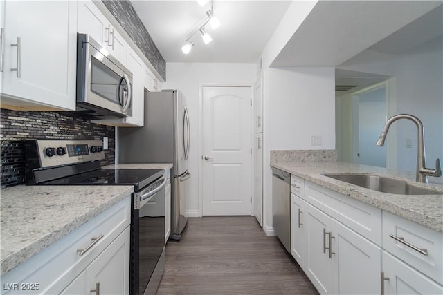 kitchen featuring white cabinetry, sink, light stone countertops, and appliances with stainless steel finishes