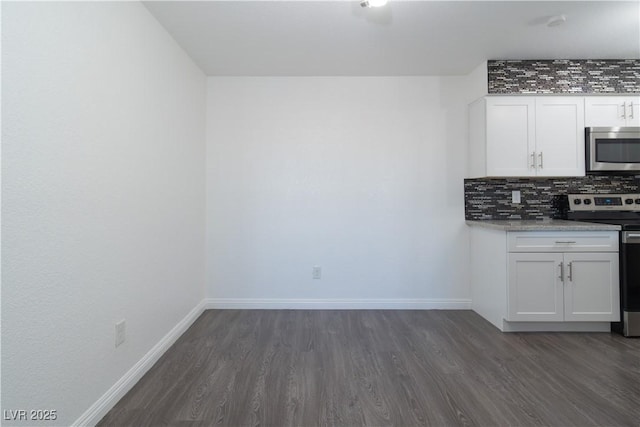 kitchen with white cabinets, dark hardwood / wood-style floors, stainless steel appliances, and tasteful backsplash