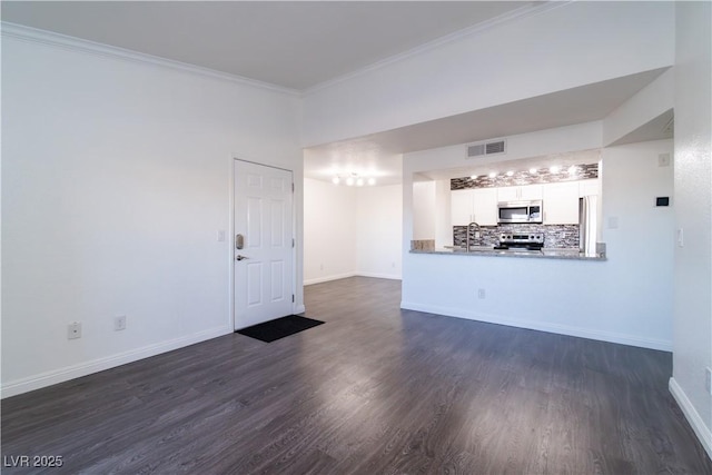 unfurnished living room featuring dark wood-type flooring, crown molding, and sink