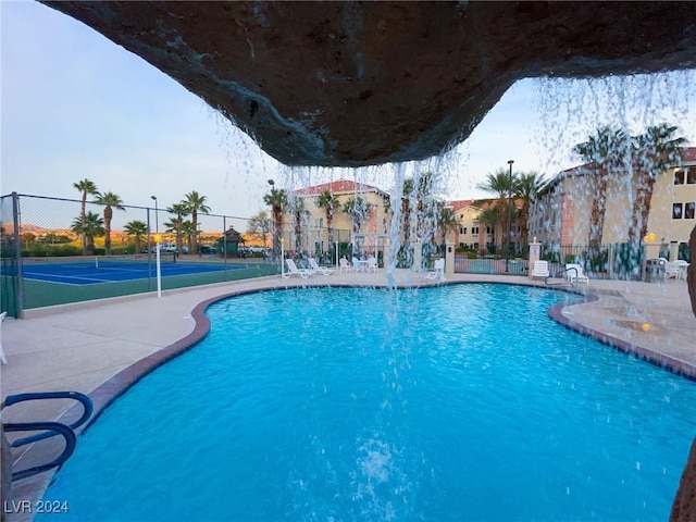 view of pool featuring pool water feature and tennis court