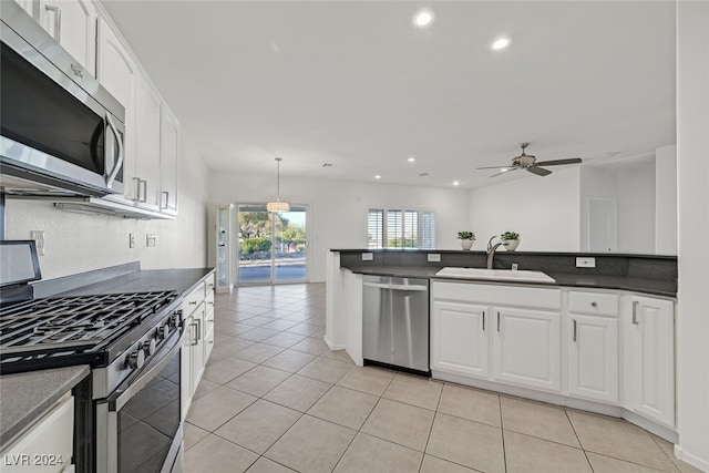 kitchen featuring ceiling fan, sink, stainless steel appliances, pendant lighting, and white cabinets